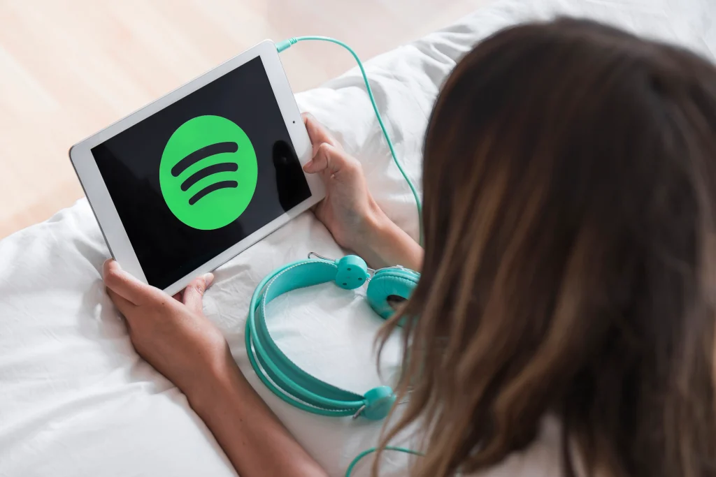 young woman holding tablet with spotify app 1